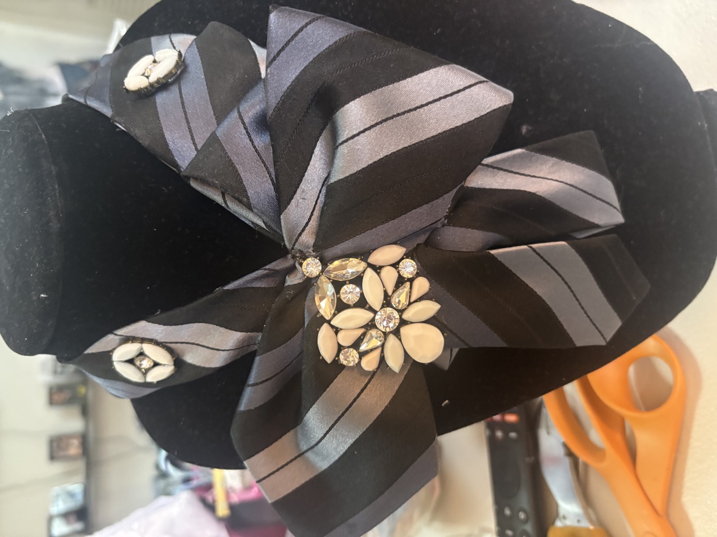 Grey striped satin necktie in a layered bow with two mother-of-pearl buttons and a crystal cluster.