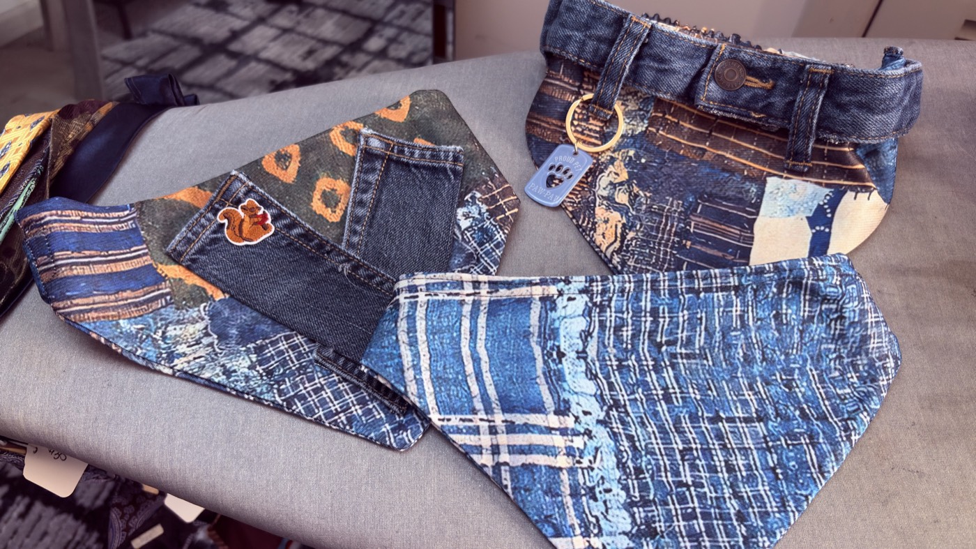Patchwork denim bandanas with a back-pocket and a squirrel patch, next to a denim collar with a brass ring.